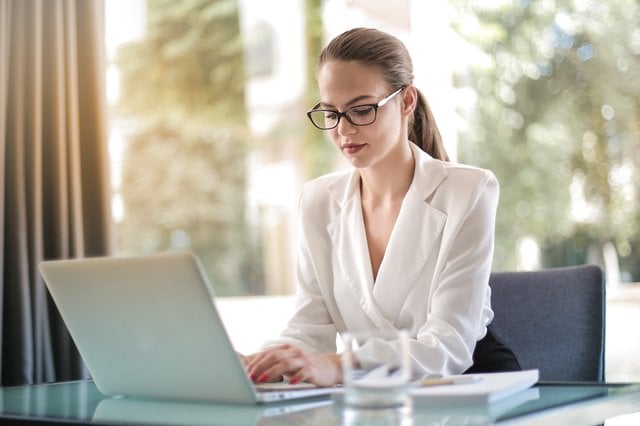 Woman with glasses sitting at laptop
