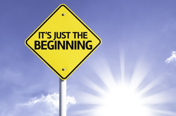 It's Just The Beginning road sign with sun background